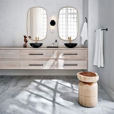 a bathroom with two sinks and mirrors on the wall