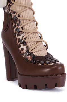 Release your inner wild side in The AZALEA WANG Finlea Brown Multi Material Bootie. These one-of-a-kind shoes feature a PU upper with a variety of colorblocked textile accents including a faux leather leopard print, a ribbed knit front panel, a faux suede tongue, and faux suede patches and trim. They also boast a lace-up, combat-style front panel, a fringed faux snakeskin panel with metallic grommets at the toe box, and a fold-over faux sherpa ankle panel. Complete with a textured platform sole for traction, a towering chunky heel, and faux suede tassels that dangle above the heel.  - PU Upper - Almond Toe - Textured Platform Outsole - Chunky Heel - Imported (all measurements approximate from size 7.5) - 4.5” Heel Height - 1” Platform Height - 6.5” Shaft Height  - 12” Shaft Opening Circumf Brown High Heel Boots With Lug Sole, Brown Ankle Lace-up Boots With Rubber Heel Cap, Brown Lace-up Boots With Rubber Heel Cap For Fall, Brown High Ankle Booties With Reinforced Heel, High Ankle Brown Booties With Reinforced Heel, Multicolor High Ankle Platform Boots, Brown High Heel Boots With Rubber Heel Cap, Brown Platform Ankle Booties, Brown Heeled Boots With Rubber Heel Cap For Fall