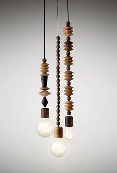 three light bulbs hanging from the ceiling next to each other with wood beads on them