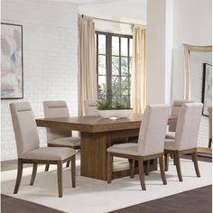 a dining room table with beige chairs and a white rug