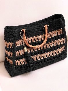 a crocheted bag with an elephant handle and tassels on the handles