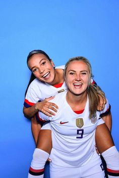 two female soccer players are posing for a photo with their arms around each other and smiling at the camera