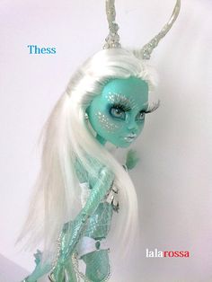 there is a doll with white hair and blue makeup on it's face,