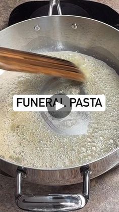 a frying pan filled with food on top of a stove next to a wooden spatula