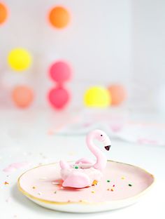 a pink flamingo on a plate with confetti