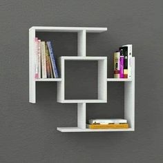 a white shelf with books on it against a gray wall in an office space or study area