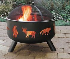 an outdoor fire pit with animals painted on it's sides and flames coming out