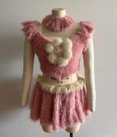 a mannequin wearing a pink and beige dress with fur on it's chest