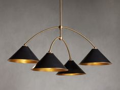 three black and gold pendant lights hanging from a brass ceiling light fixture in a room