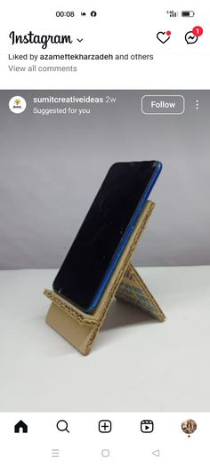 an instagram page with a gold and blue phone on it's stand, which is attached to a white background