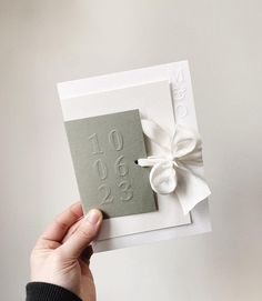 a person holding up a card with a bow on it