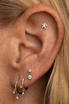 a woman wearing three different ear piercings