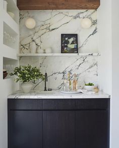 a kitchen with marble counter tops and shelves