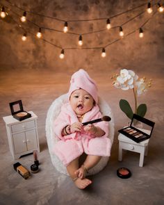 a baby in a pink robe is holding a brush