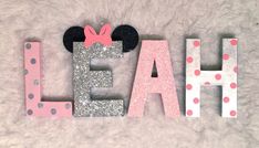 the letters have minnie mouse ears and are painted pink, silver and white with polka dots