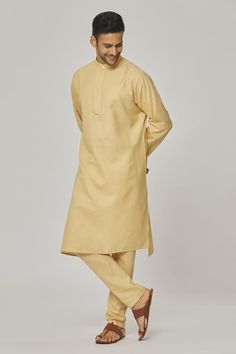 Dawn yellow cotton kurta with asymmetric hemline. Comes with pyjama.
Components: 2
Pattern: Solid
Neckline: Band collar
Sleeve Type: Full
Fabric: Cotton
Color: Yellow
Other Details: 
Closure : Kurta - Front buttons
Occasion: Mehendi and Puja - Aza Fashions Cotton Sherwani With Naqshi For Festivals, Festival Cotton Sherwani With Naqshi, Cotton Naqshi Sets For Festive Occasions, Festive Cotton Sets With Naqshi Detail, Festive Cotton Naqshi Sets, Eid Cotton Kurta With Naqshi Embroidery, Diwali Cotton Naqshi Sets, Unstitched Cotton Churidar, Cotton Sherwani With Naqshi For Diwali