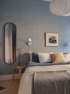 a bed sitting in a bedroom next to a mirror on the side of a wall