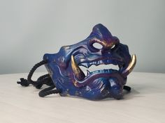 Awesome Japanese Samurai Oni Demon Mask will complement your cosplay costume or party look! Bright colors, easy to wear, super lightweight! Features: - Super Lightweight and Extra Durable (casted of Polyurethane plastic) - ALREADY FINISHED, POLISHED AND PAINTED - Attachment - Black cord + Straps Size: - width 6.7" (17 cm) - height 5.1" (13 cm)  Fits a regular human head You will receive: - Mask (finished, painted, varnished) *Doesn't need any finishing. Buy. Receive. Wear.* You can contact me fo Blue Oni Mask, Oni Demon Mask, Yasukuni Shrine, Demon Mask, Oni Demon, Your Cosplay, Oni Mask, Half Mask, Chip Carving