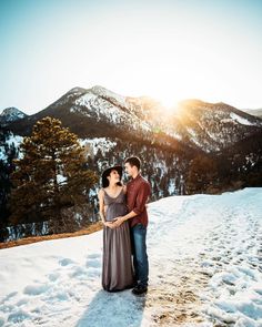 a man and woman standing in the snow together