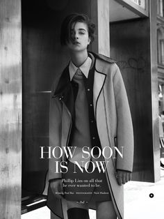 a woman standing in front of a building wearing a trench coat and tie with the words how soon is now?