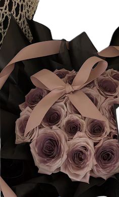 a bouquet of roses is wrapped in black paper