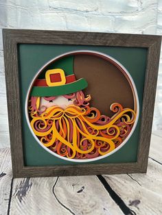 a paper cut out of a man wearing a green hat and orange hair with an octopus on his head