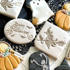 decorated cookies are arranged on a black and white doily with the words happy halloween