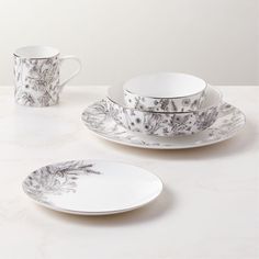 a white table topped with plates and cups filled with saucer, cup and saucer