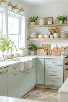 a kitchen filled with lots of white counter tops and wooden shelves next to a window