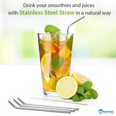 a glass filled with lemonade and mint next to two drinking straws on a white surface