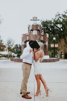 a man and woman kissing in front of a building