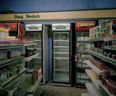 two refrigerators in a grocery store with food on the shelves next to each other