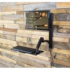 a laptop computer mounted to the side of a wooden wall next to a light fixture