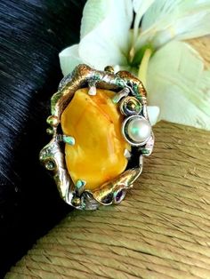 "Very Unique Baltic Amber Gemstone Ring in sterling silver with 24k Gold accents Hand-made Sterling Silver, 24k Gold, Size 9 Stones used: Baltic Amber, Pearl, Amethyst Face of the ring: Height - 40mm, Width-30mm Height - 1 3/8\", Width-1 1/4\" Band height - 10mm Unique Handcrafted One-of a-kind Design Ring Each Piece of Jewelry in my Collection is Absolutely One of a Kind! When you start wearing a piece of my jewelry you will fall in love with it more and more each day and feel that good Energy Artisan Multi-stone Ring Jewelry, Artisan Multi-stone Ring, Unique Multi-stone Gold Gemstones, Gold Multi-stone Gemstones, Unique Gold Gemstones For Wedding, Yellow Multi-stone Fine Jewelry, Gold Opal Ring In Sterling Silver, Gold Sterling Silver Rings With Natural Stones, Unique Oval Gold Gemstones