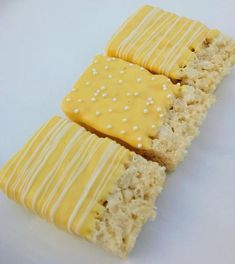 three pieces of cake with yellow icing and white sprinkles on them