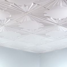 a room with white walls and ceiling tiles