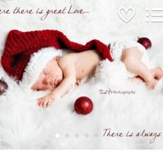 a baby wearing a santa hat laying on top of a white blanket next to christmas ornaments