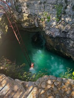 a man is swimming in a pool with stairs leading up to the water's edge