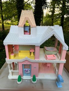 a pink doll house with furniture and accessories