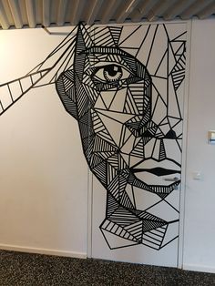 a drawing of a woman's face is on the wall next to a door