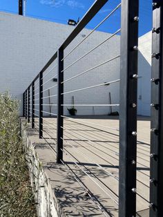 an empty parking lot next to a white building with metal railings on it's sides