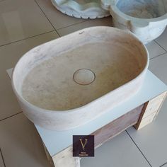 a large stone sink sitting on top of a white counter next to two smaller bowls