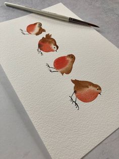 three little birds sitting on top of a piece of paper next to a marker pen