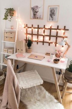 a white desk topped with a laptop computer next to a shelf filled with books and plants