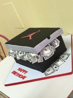 a birthday cake made to look like a box with money in it