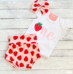 two pieces of clothing with strawberries on them, one is pink and the other is white