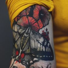 a woman's arm with a butterfly and flowers on it