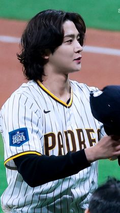 a baseball player holding a glove on top of a field