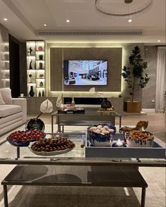 a living room filled with furniture and a flat screen tv mounted to the side of a wall