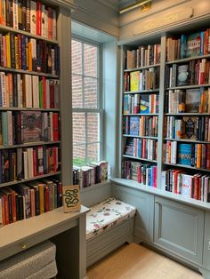 there are many books on the shelves in this room and one has a bench for reading